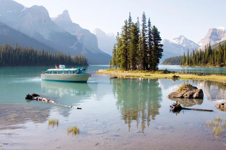 a small boat in a body of water with a mountain in the background