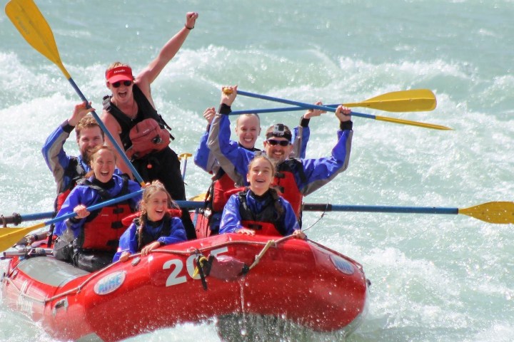 a group of people riding on the back of a boat in the water