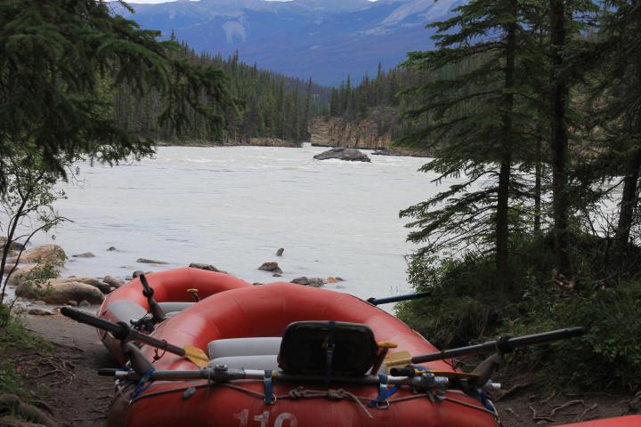 a red motorcycle parked on the side of a lake