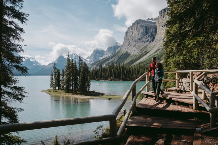 a man sitting on a bench next to a body of water