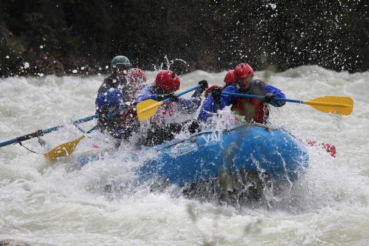 a group of people riding skis on a raft in the water