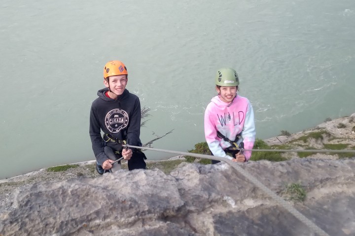 a man sitting next to a body of water